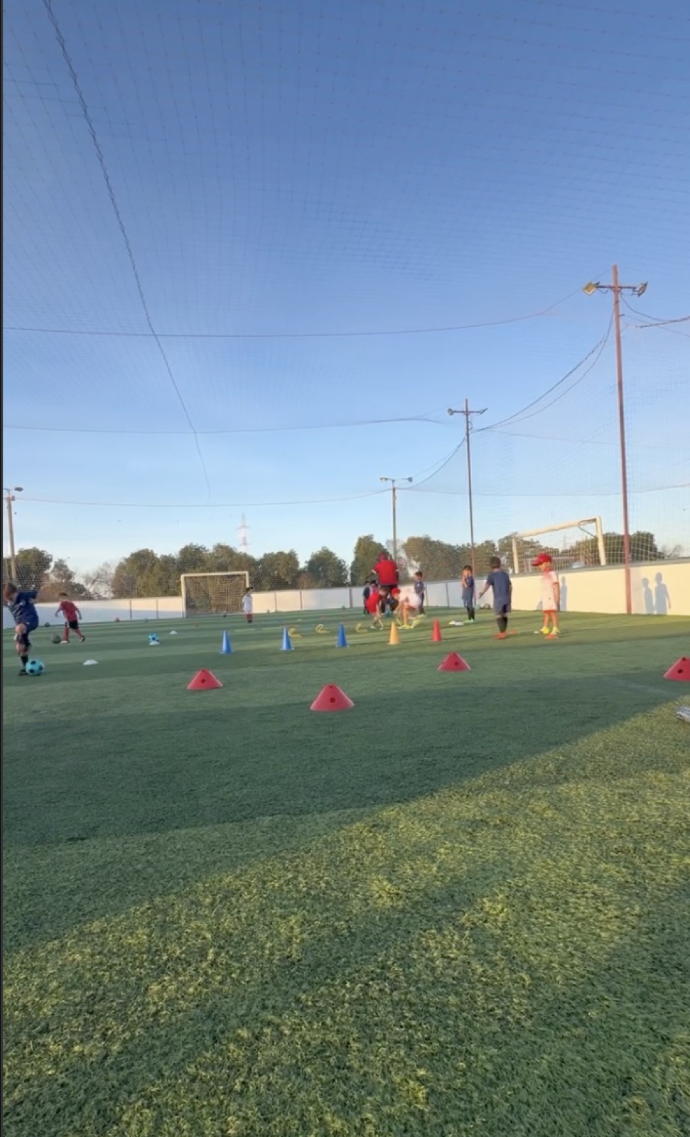 Enfants à l'entraînement sur le terrain de Palmarena, au coucher du soleil