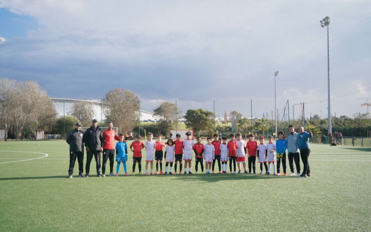 Une équipe de l'Academy alignée avec ses éducateurs avant un match à l'extérieur